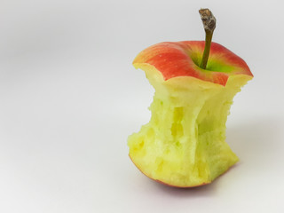The apple core lies on a white background, and wants to be eaten or thrown away.