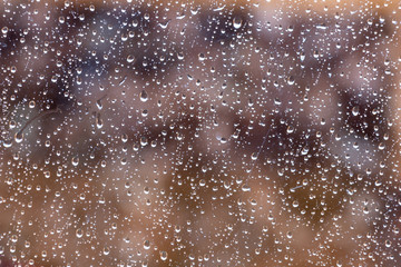 image of raindrops on glass with beautiful natural colors background behind.
