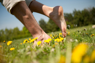 Fototapeta na wymiar Close-up of legs. Young man on a meadow.