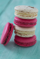 raspberry and vanilla macaroons on turquoise wooden surface