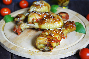 Grilled spicy chicken legs on a black background.Top view. backet chicken on paper