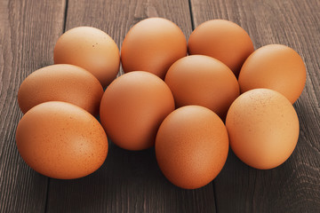 Closeup side view of fresh brown chicken eggs with shallow depth of field on rustic rural wooden vintage background