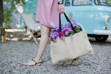 Woman with eco bag from sackcloth with pink and purple flowers