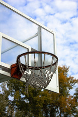 Basketball backboard and basket in the park on a cloudy and light day