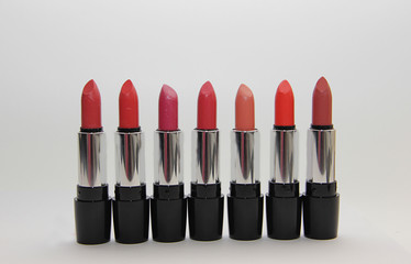 a set of lipsticks of bright colors stand in a row close-up