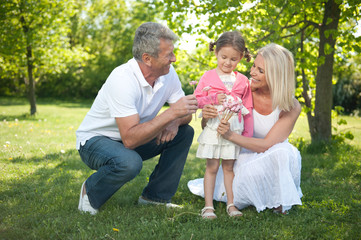 Happy senior couple with child in a park