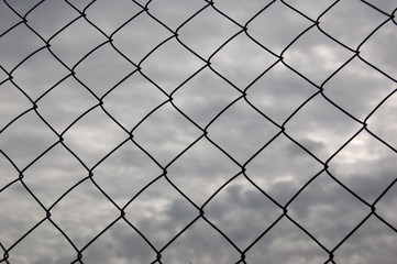 Metal mesh, a fence, against the sky