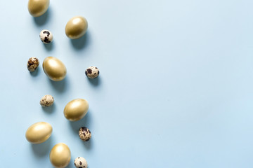 Easter decor of golden chicken eggs on pastel blue. Top view. Happy Easter holiday. Greeting card.
