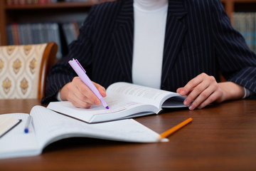 The girl student in the library does homework