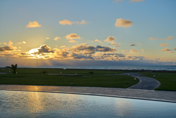 warm sunset reflection on pool with beautiful clouds. wonderful summer green courtyard by the...