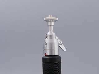 metal mini tripod for the camera on a gray background