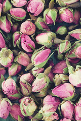 dried rose buds on turquoise wooden surface