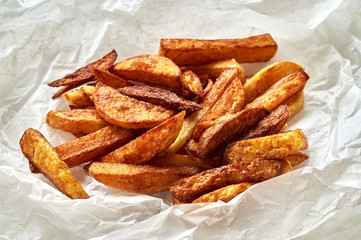 Tasty homemade potato french fries on white paper background