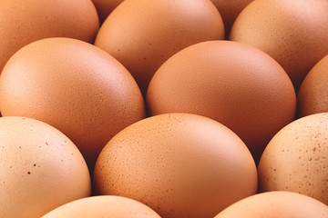 Close up of fresh brown chicken eggs with shallow depth of field. Abstract trendy food rustic texture background