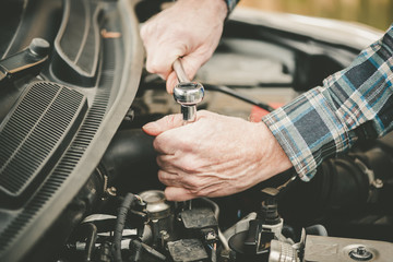 Hands of car mechanic working on car engine
