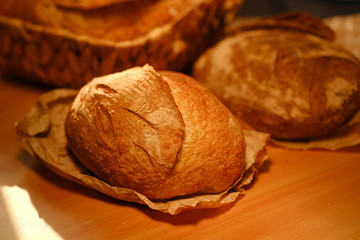 Assortment of baked bread on wooden table background. Bread background, top view of white, black and rye loaves. Healthy food. 