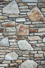 limestone wall in different shades of brown and ochre, photograph in vertical position, for background in graphic resources or catalogue of construction materials.