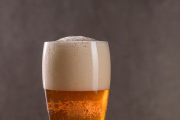 fresh beer in a glass on the background