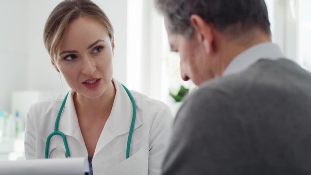 Handheld view of senior man and doctor in doctor&rsquo;s office. Shot with RED helium camera in 8K 