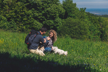 Young couple enjoying hiking together in nature whit their dogs.