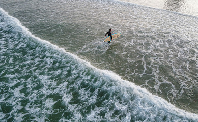 Surfer steht in der Brandung; Port Elizabeth, Südafrika