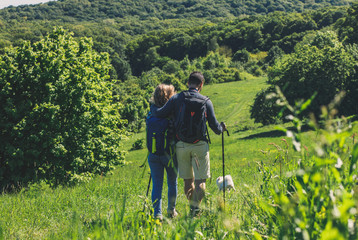 Young couple enjoying hiking together in nature whit their dogs.