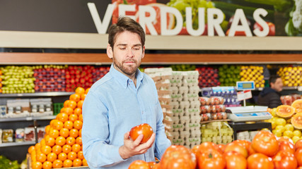 Young man as a customer buying vegetables