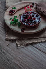 Cheesecake with blueberry and raspberry jam on a plate with a wooden spoon, peppermint and a napkin