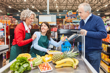 Saleswoman helps trainee at the supermarket cashier