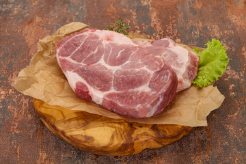 Raw pork steak over wooden board