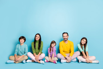 Nice attractive lovely cheerful cheery pleased family schoolkids mom dad sitting in lotus pose...
