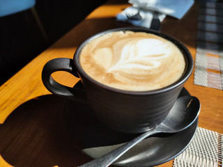 Close-up Cappuccino Coffee on wood table in morning.