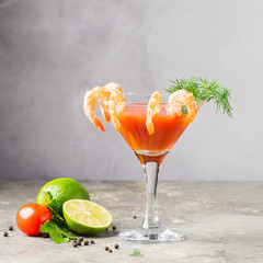 Cocktail tomatoes shrimp lemon juice sprig of dill and ingredients an elegant glass. Traditional drink gray background.