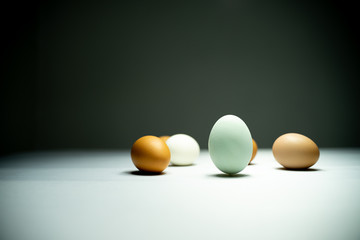 Many eggs are in a white table in the dark.