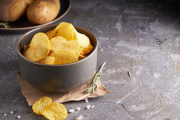 potato chips in a gray bowl on a gray background
