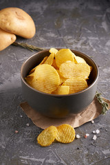potato chips in a gray bowl on a gray background