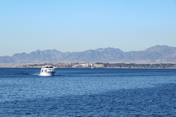 View of the Bay with rocks and drifting boat.