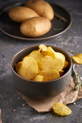 potato chips in a gray bowl on a gray background