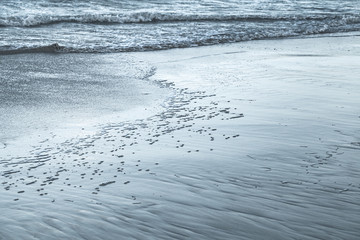 Wet shore sand and sea water