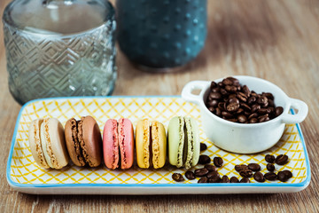 Assortiment de macarons et grains de café sur une assiette colorée
