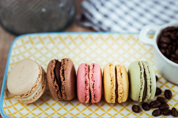 Assortiment de macarons et grains de café sur une assiette colorée