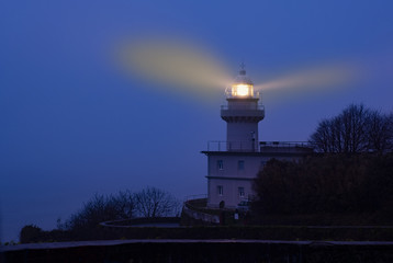 Lights in the lighthouse with fog at dawn, Igueldo, city of Donostia (San Sebastian)