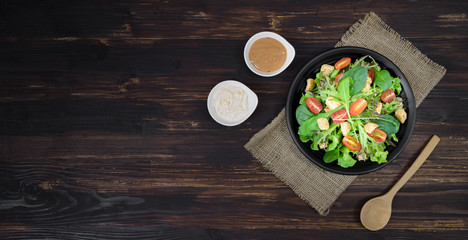 Fresh salad in bowl on wooden background