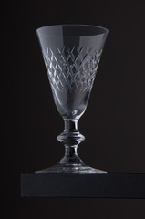 antique small glass against grey background