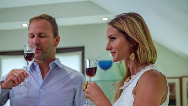 Young caucasian couple toats with glass of wine in holiday art shop.