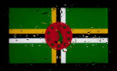 The national flag of Dominica. Abstract photo with water drops on a black background.