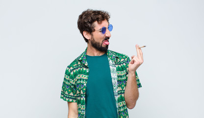 young hippie man smoking a joint against white wall