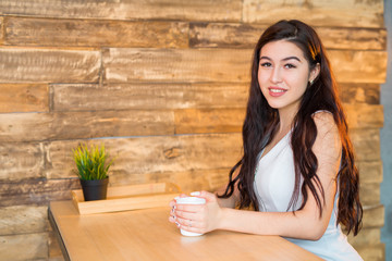 beautiful young woman at the table with a drink