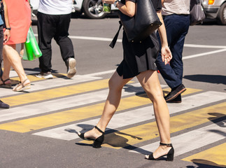pedestrians crossing the road at a crosswalk in the city