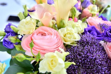 Amazing tender bouquet with pink ranunculus, violet Alstroemeria flowers and tiny white roses in cardboard box with pink ribbon. Beautiful bunch of spring flowers. Easter gift. Seasonal spring flowers